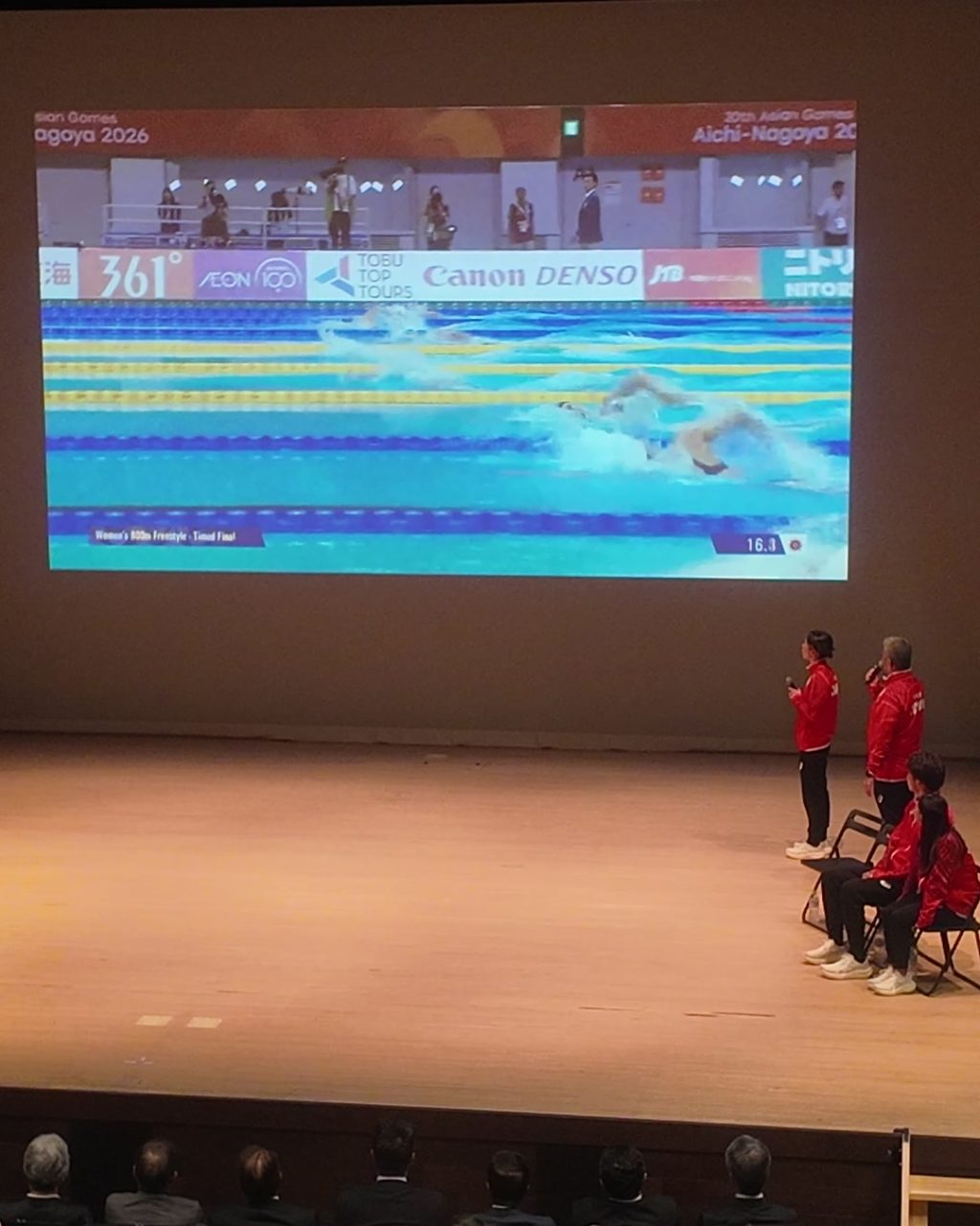 スクリーンのレース映像を見ながら大会を振り返る太田コーチと選手たち